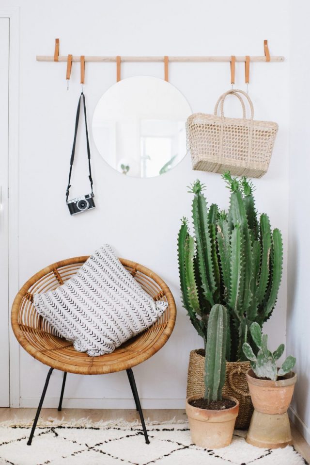 A Boho Entry With A Wicker Chair With Metal Legs